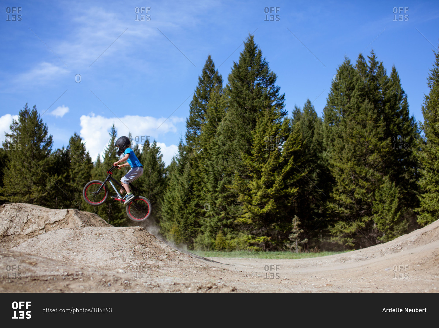 Young boy riding a bmx bike on a dirt track