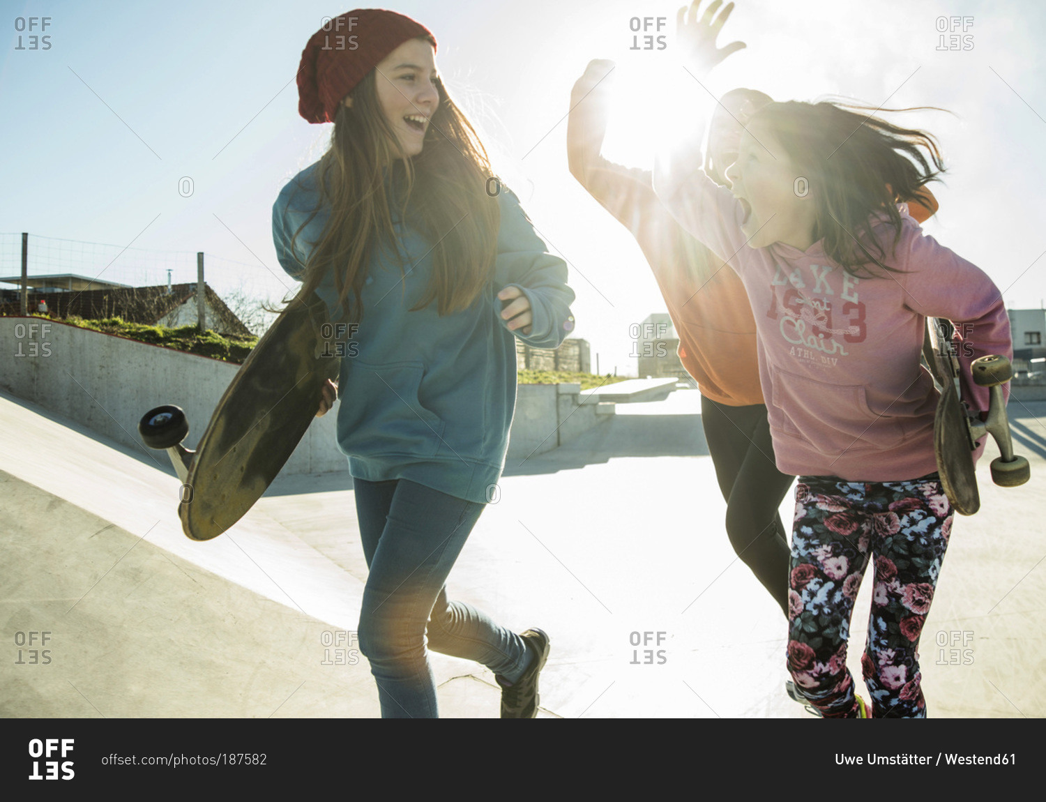 Three girls running in skate park