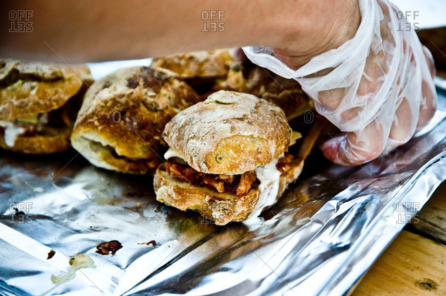 Person preparing pulled pork sandwiches