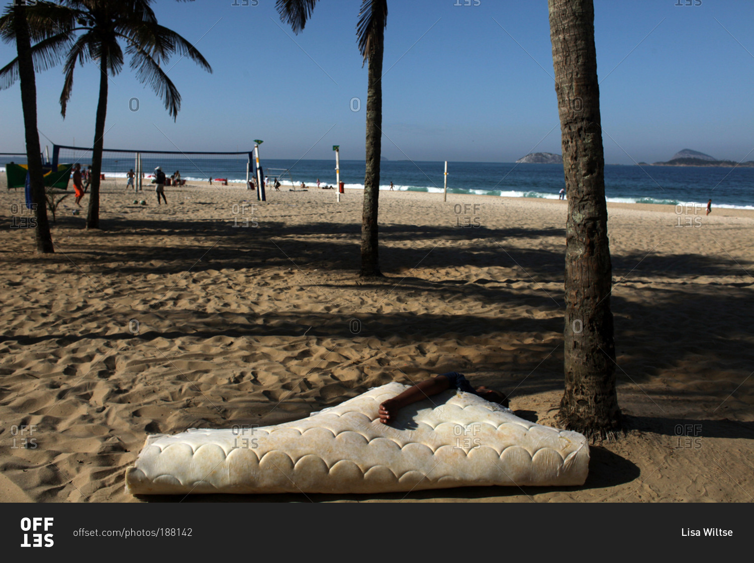 Man sleeping on an old mattress at Ipanema beach stock photo OFFSET