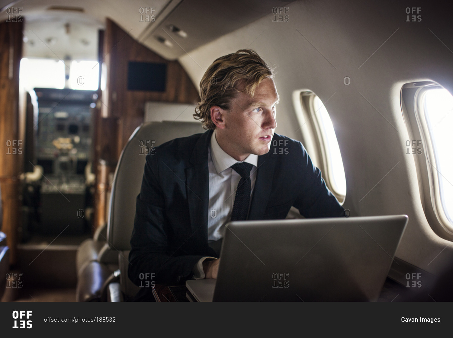 Businessman with laptop on private jet