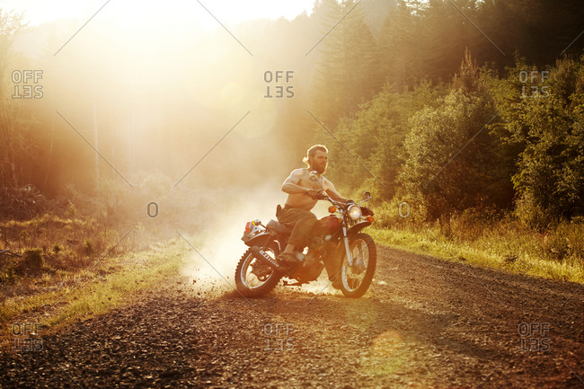 Man skidding with his motorcycle on a dirt road