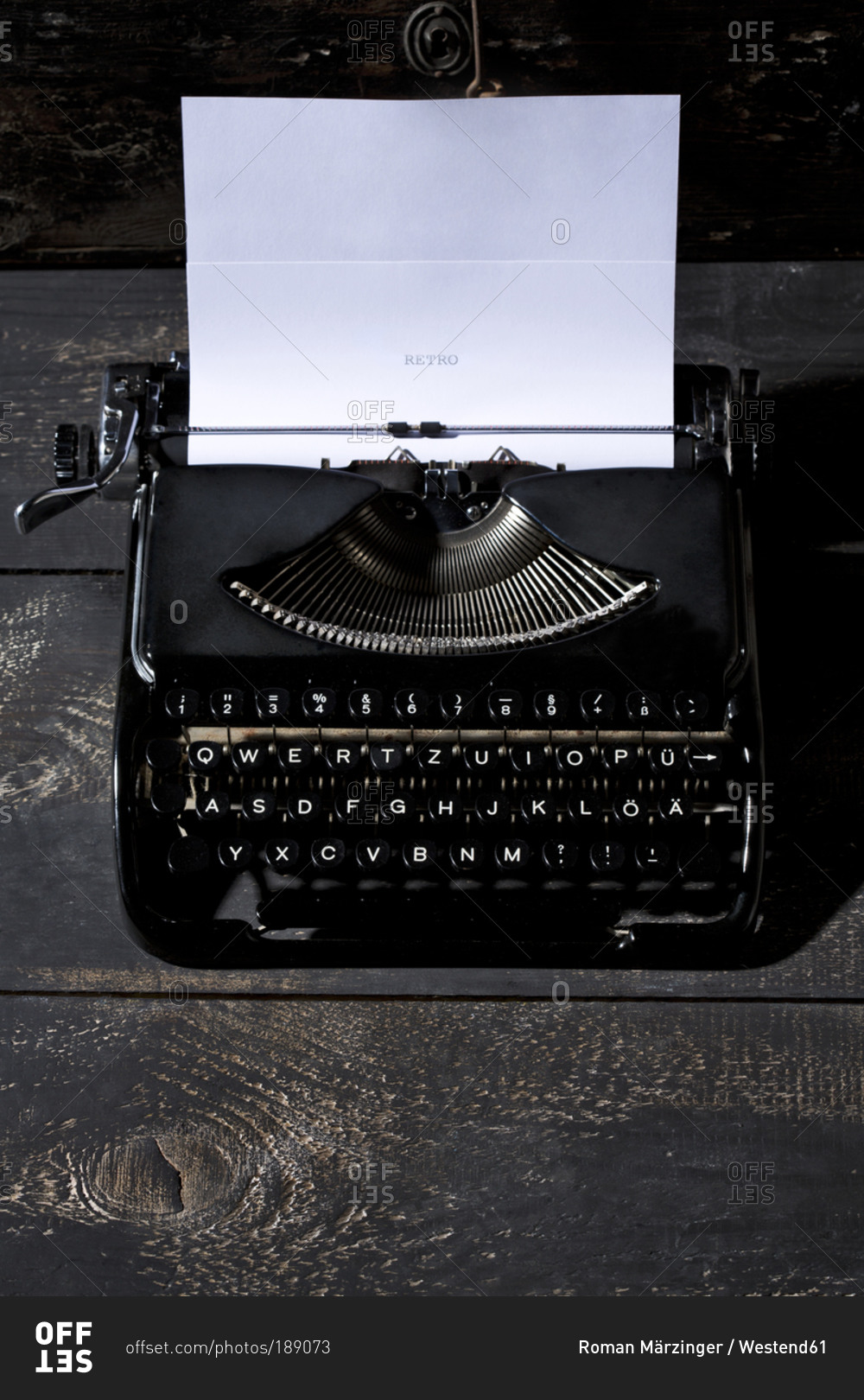 Old black typewriter on dark wood