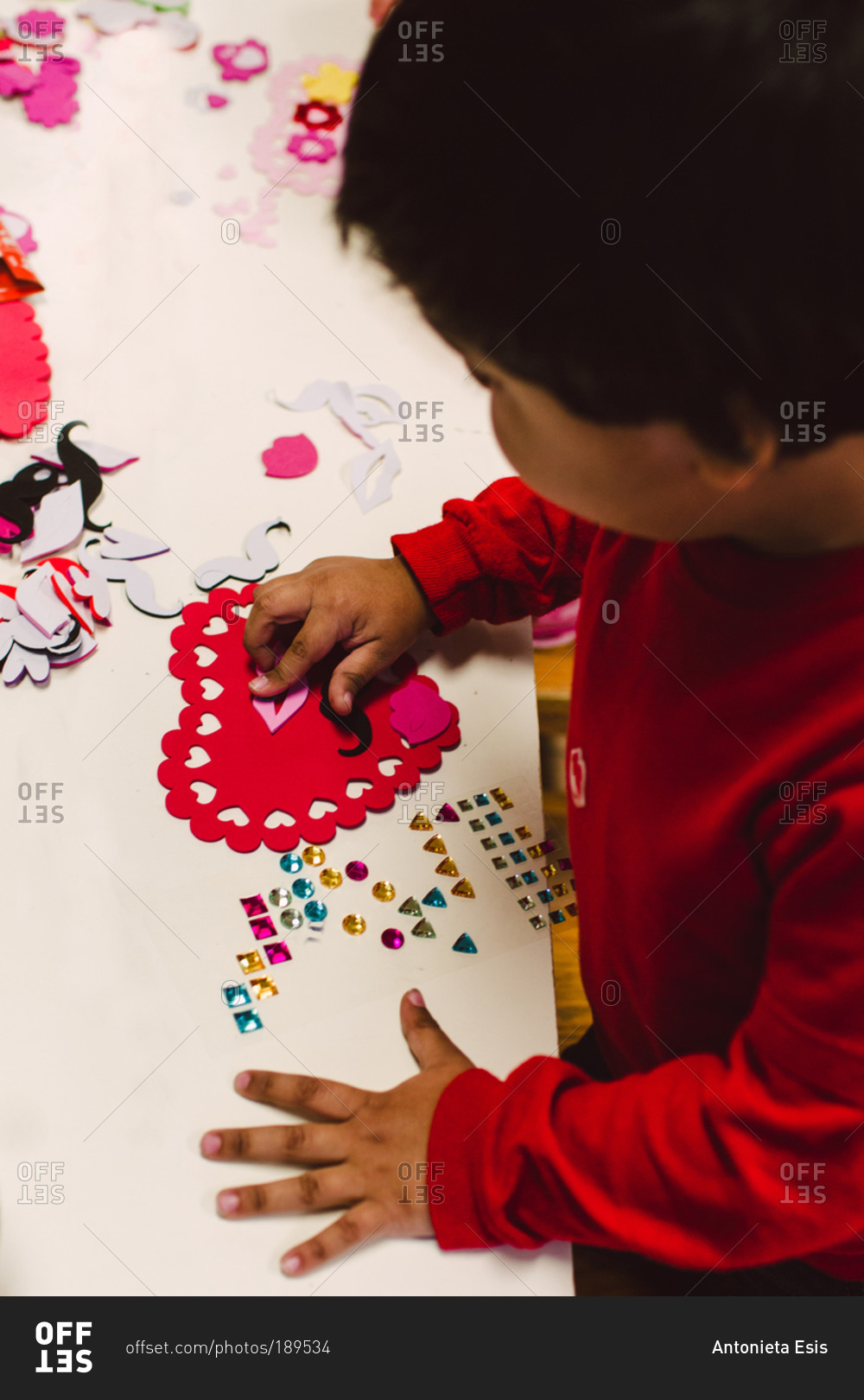 A little boy works on a Valentine's Day project