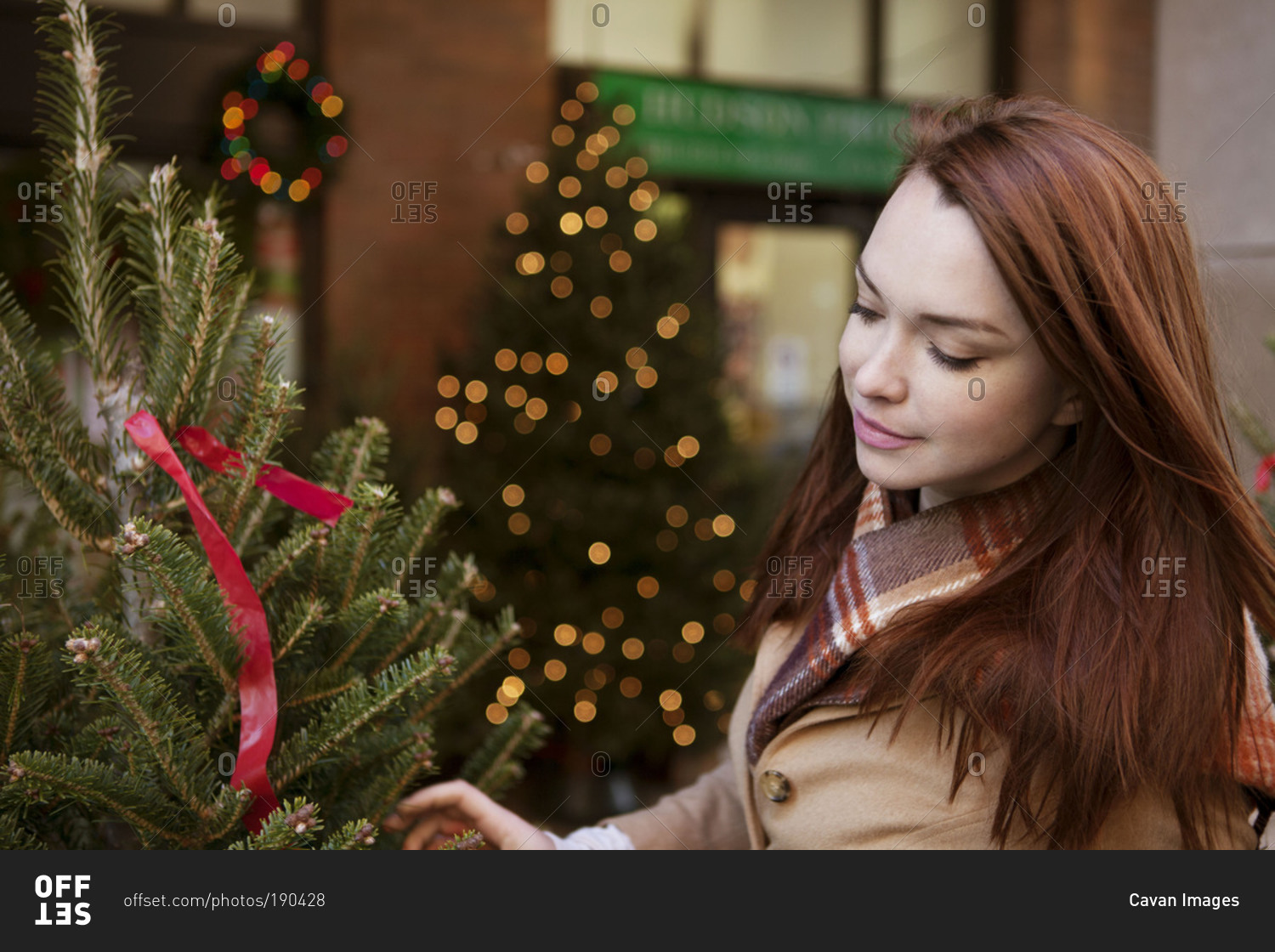 Redhead woman passing by a Christmas tree