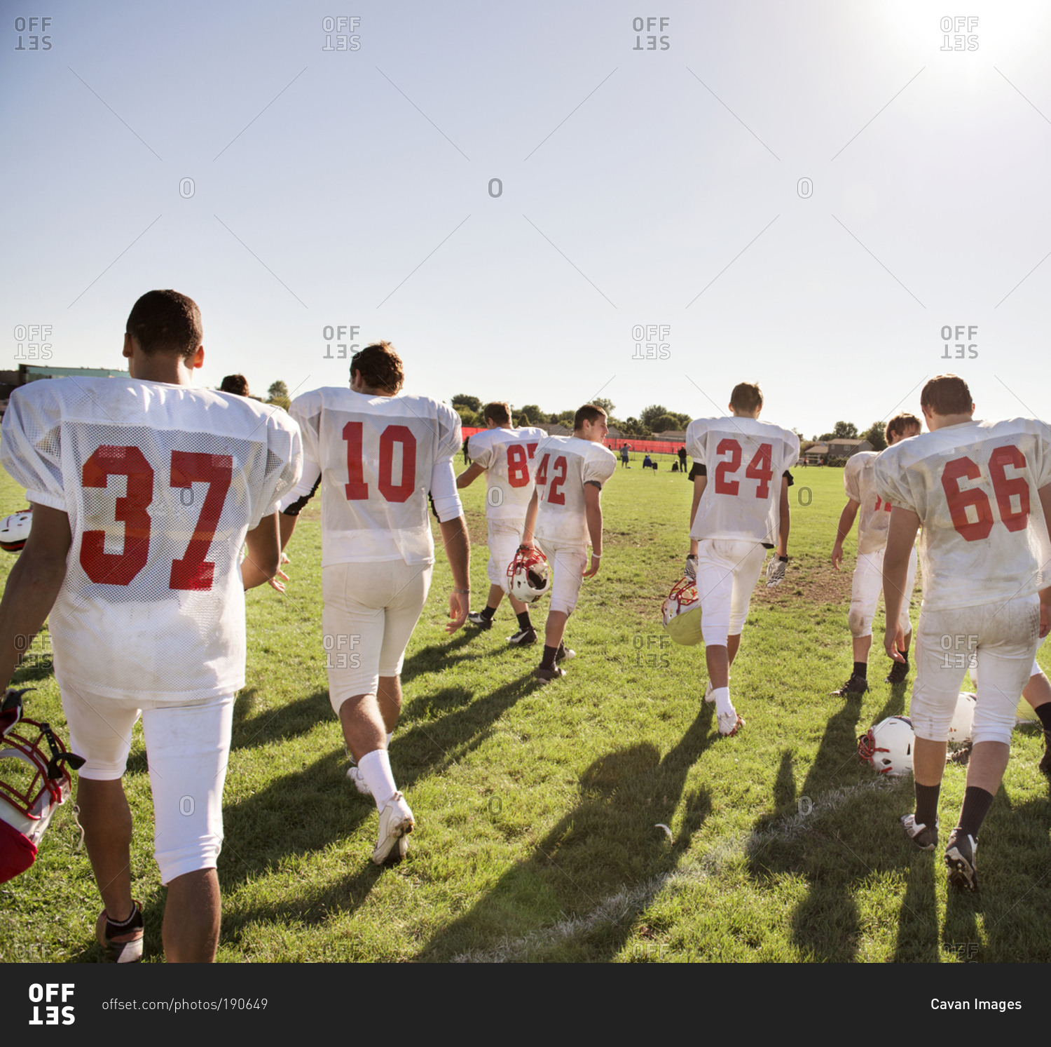 A high school football team walks onto the field