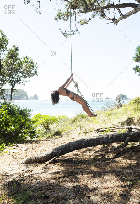 New Zealand Photos  Young girl smiling and sharing a rope swing