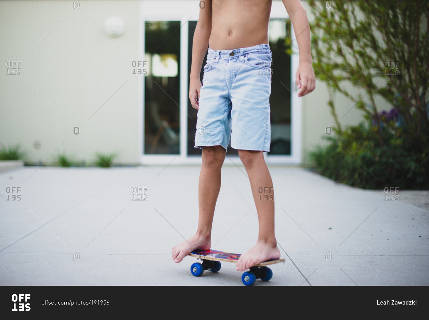 Legs and feet of boy standing still on skateboard