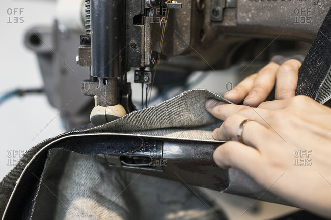 Close-up sewing seam with denim at industrial machine
