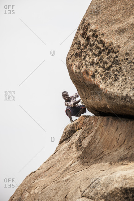 Matobo, Zimbabwe - September, 28, 2009: A child peeks out from the balancing rocks in Matopos National Park in Zimbabwe