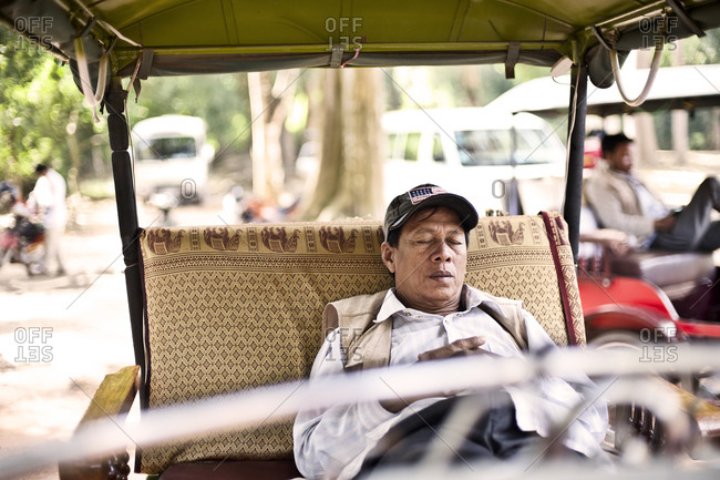 Siem Reap, Cambodia - December 19, 2014: Man sleeping in a tuk-tuk