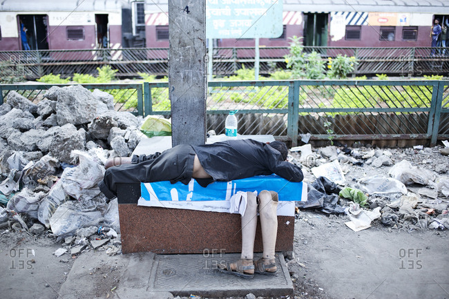 Homeless person sleeping under a bridge