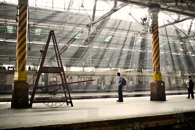 Mumbai, India - February 6, 2015: Commuters waiting for a train at a station