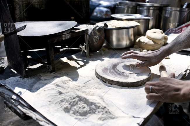 Close up of person rolling flatbreads