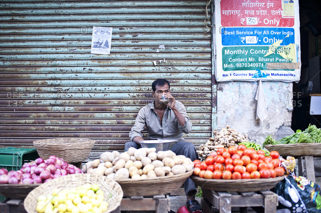 Mumbai, India - February 8, 2015: Vegetable vendor drinking chai tea