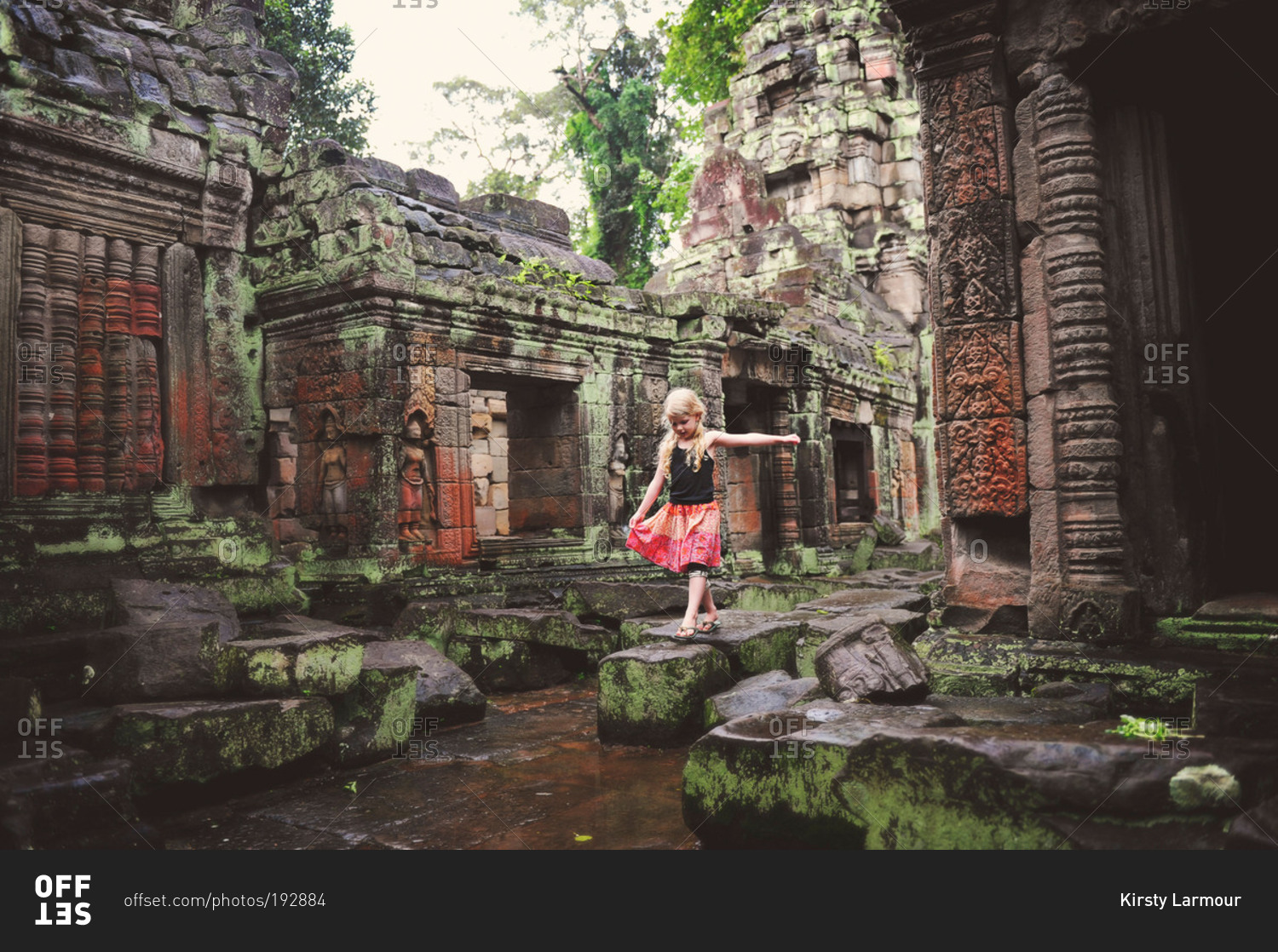 Young girl playing on the stones of an ancient temple in Cambodia