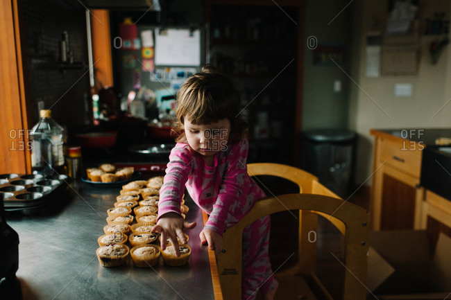 Girl lining up freshly baked muffins