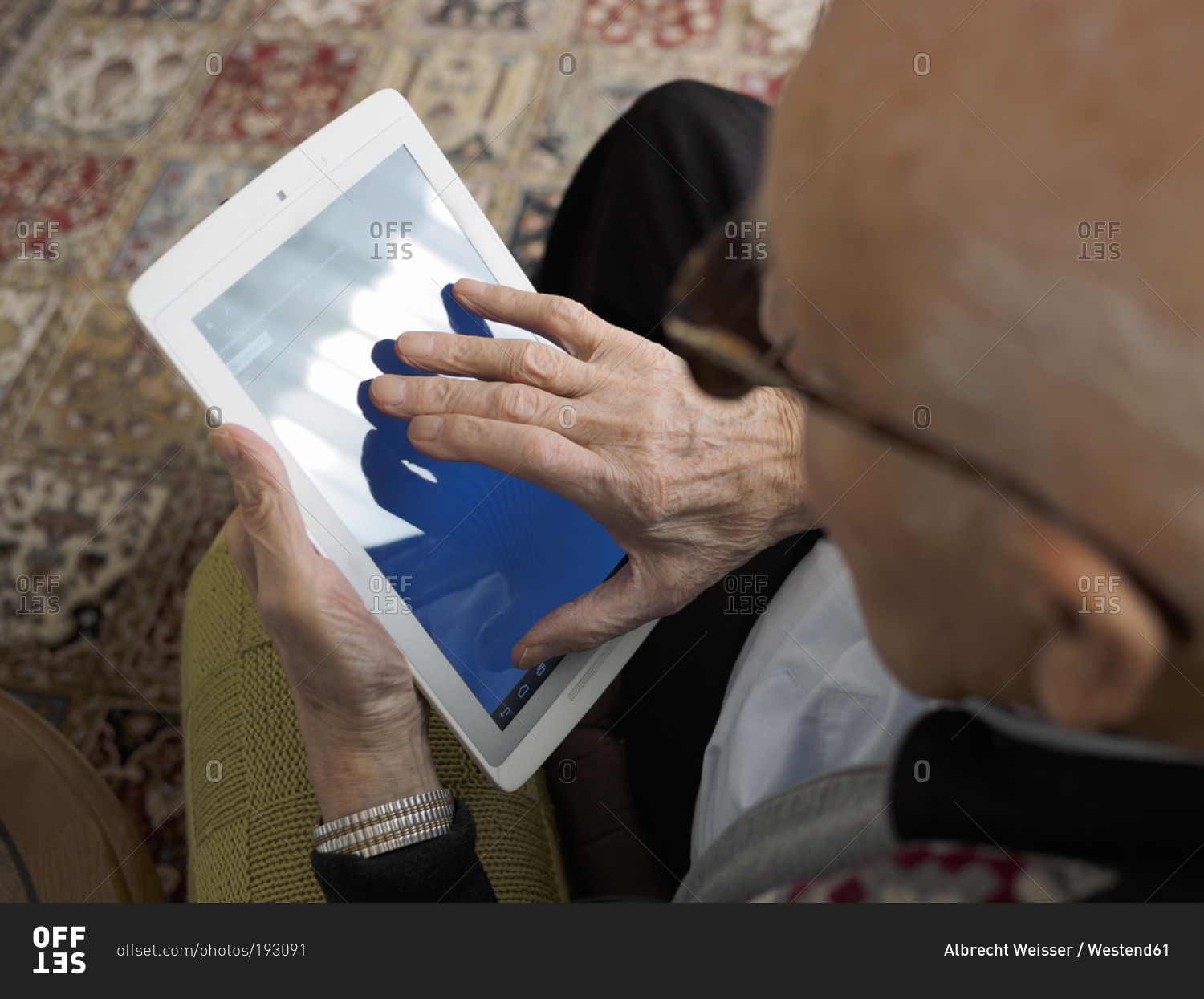 Old man at home using digital tablet