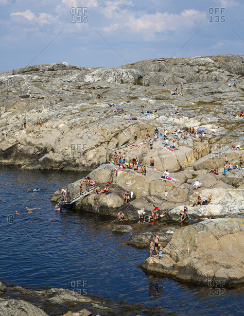 Sweden - July 21, 2014: Sunbathers on rocky coast of Weather Islands, Sweden