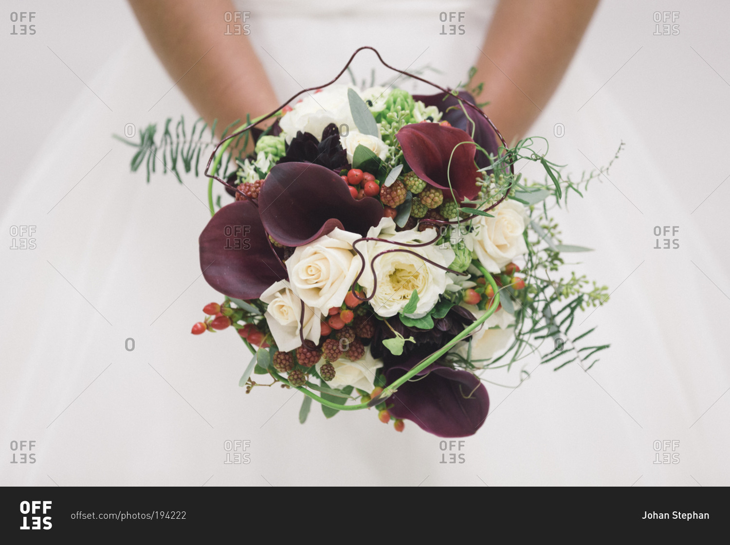Close-up of a bridal bouquet with berries and calla lilies