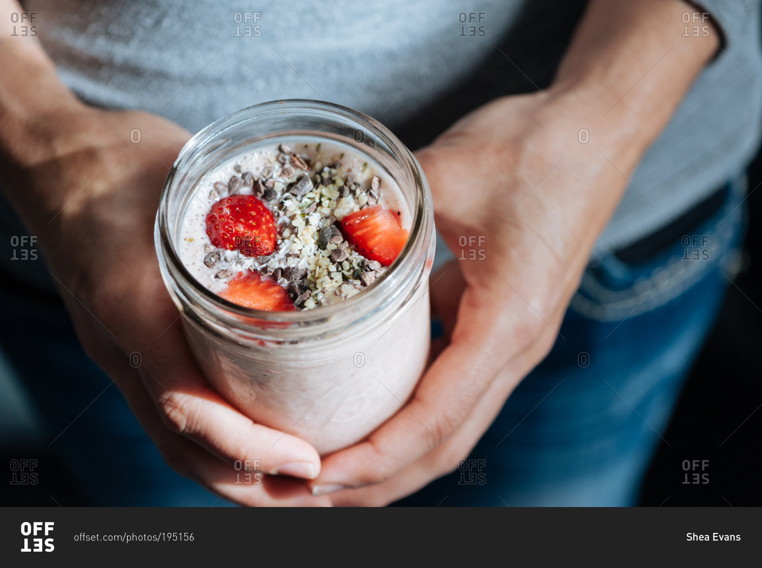 Man holding fresh fruit smoothie with strawberries, cacao nibs