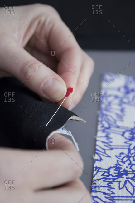 Woman pinning fabric seams together for sewing
