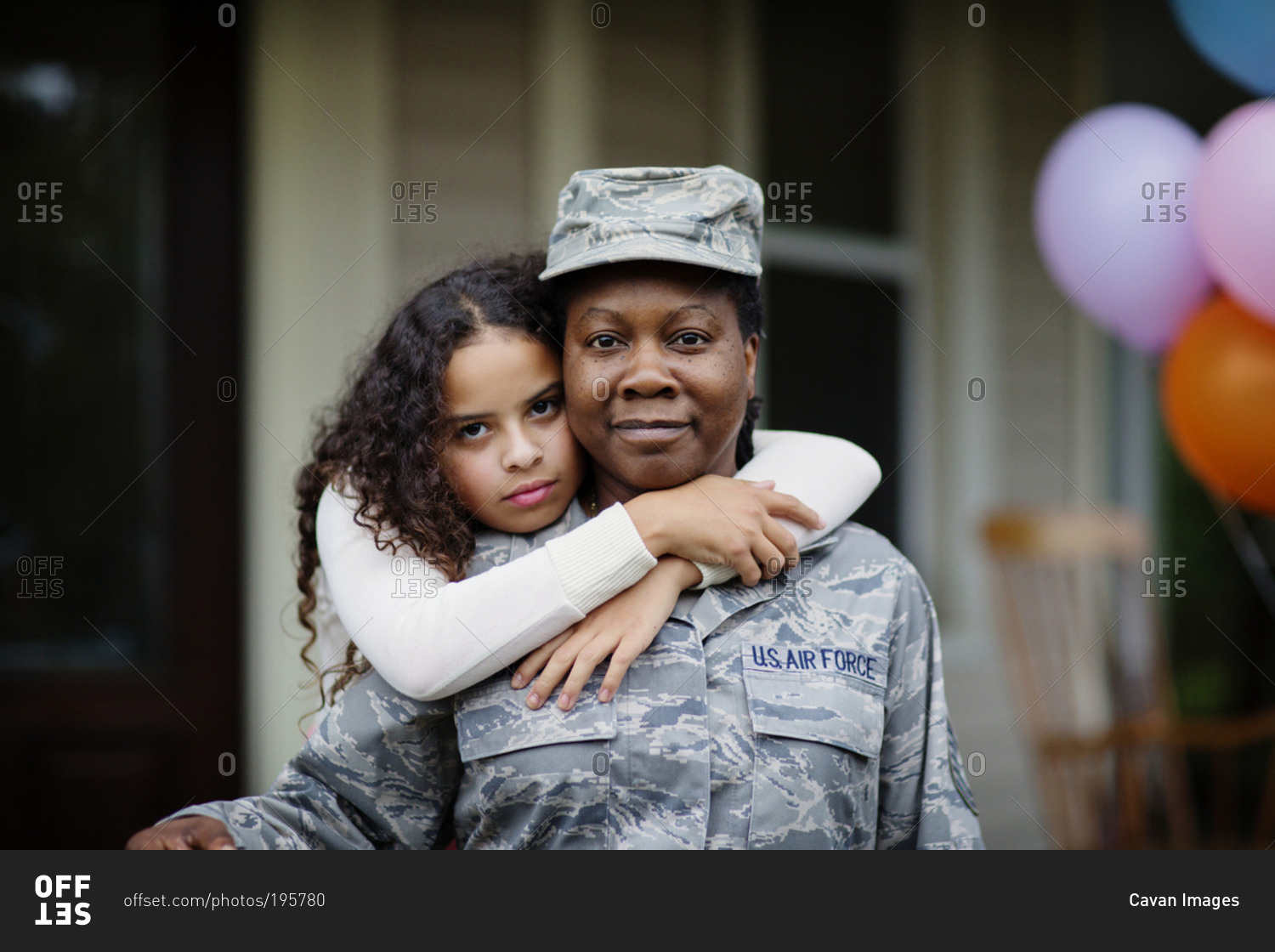 Female Air Force member receiving hug from young girl