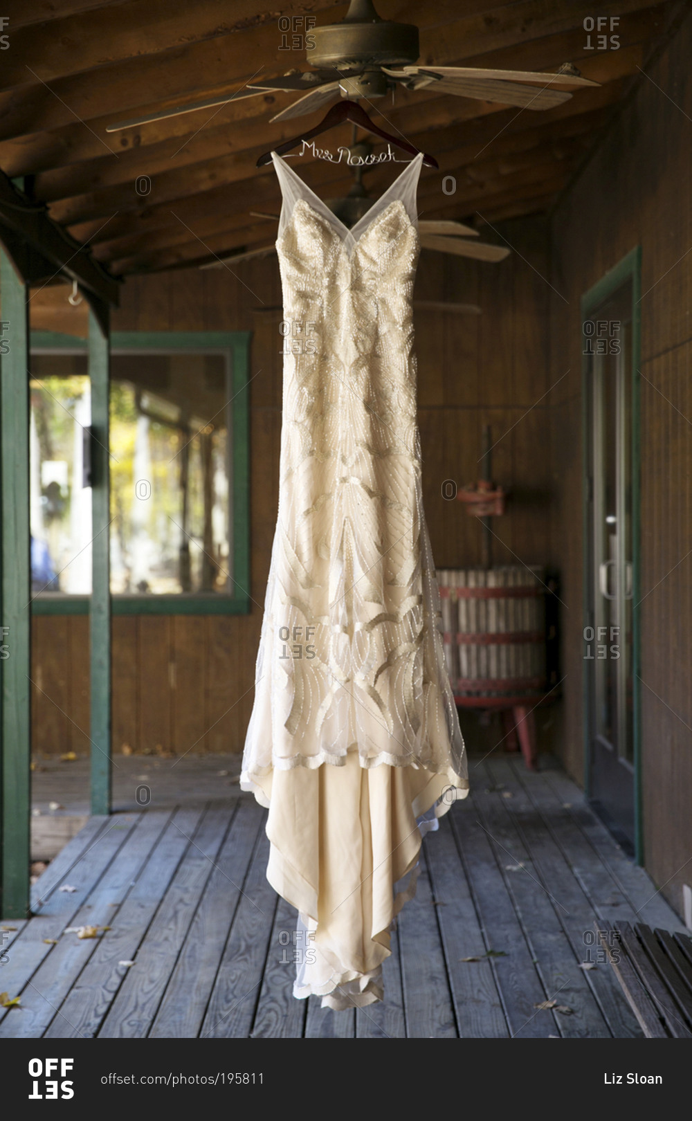 A bride's dress hangs from a ceiling fan