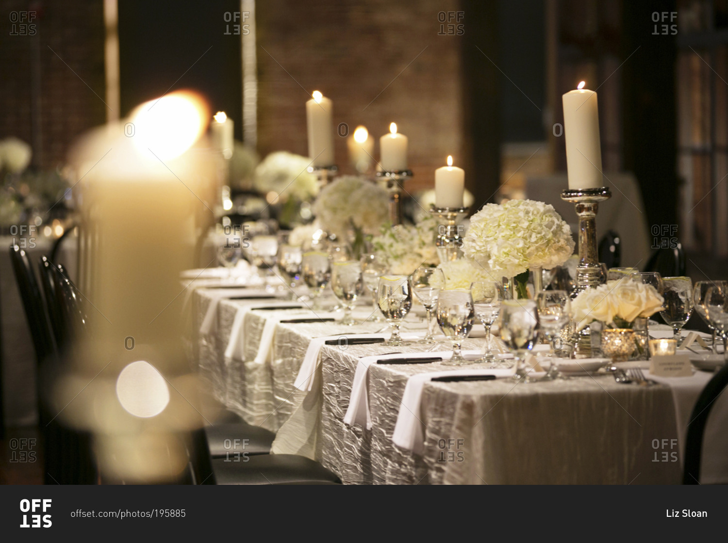 A wedding party's table set with pillar candles at a wedding reception