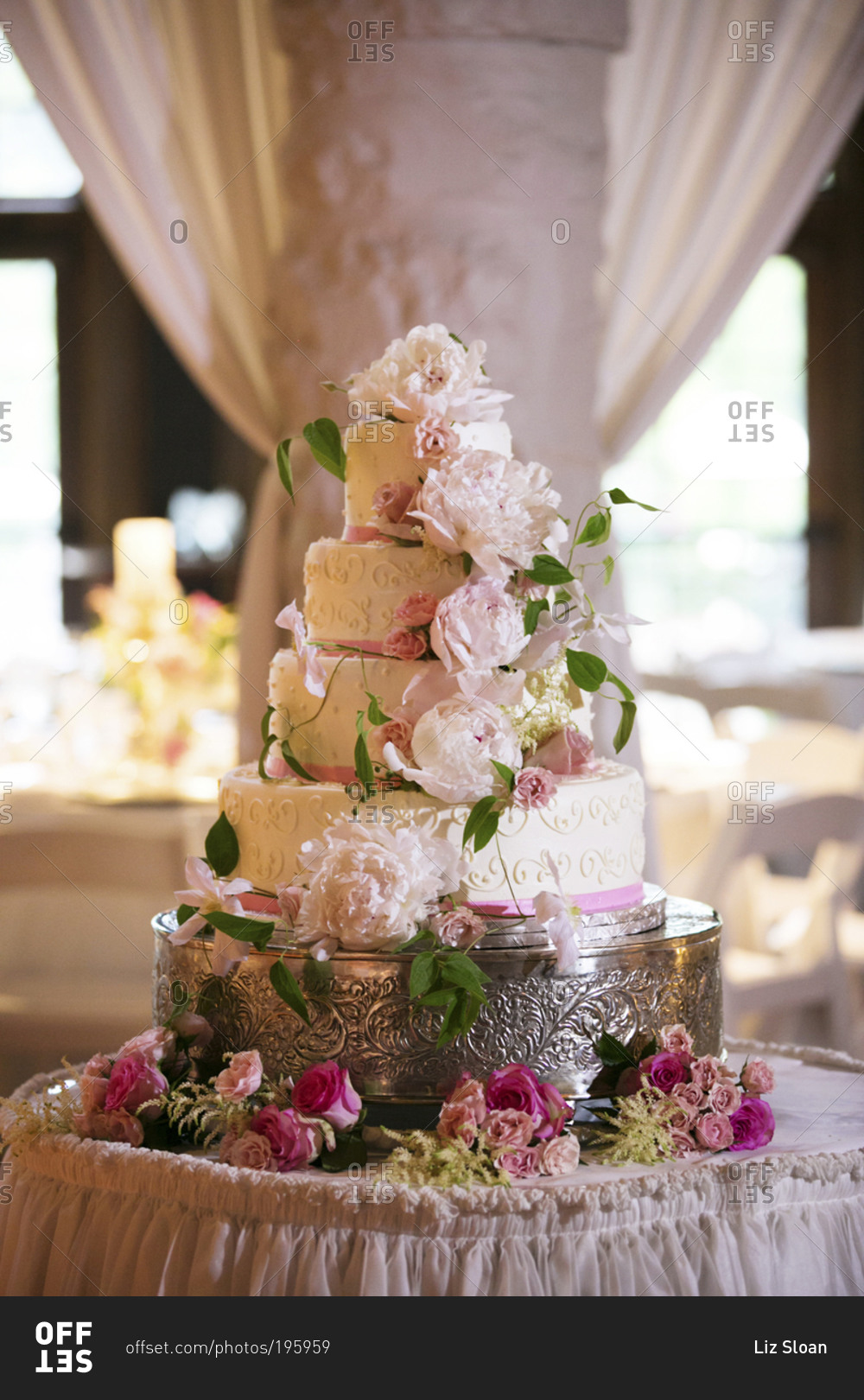 A four tiered wedding cake on a silver cake tray