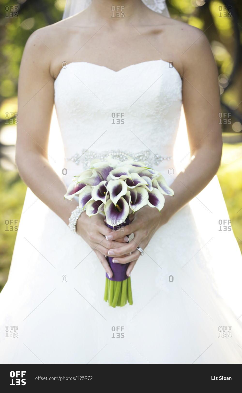 A bride holds a bouquet of calla lilies