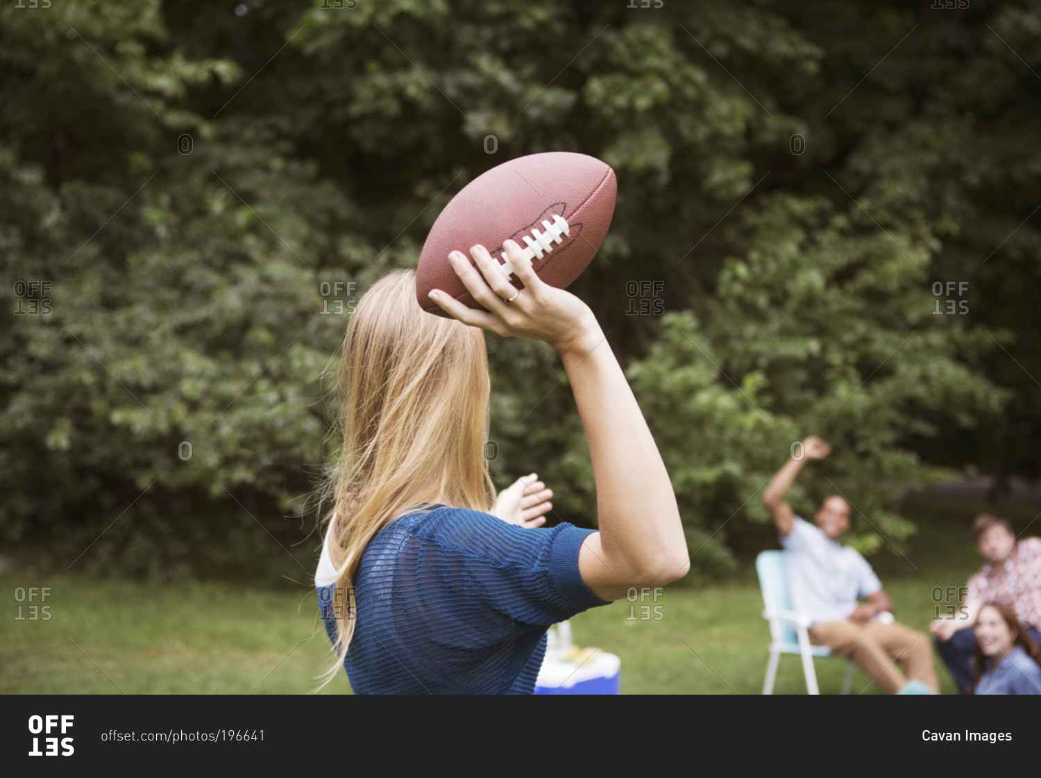 Woman about to throw football to friends
