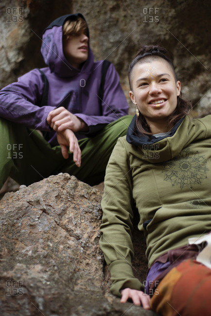 Spiritual young friends sitting on rock during hike