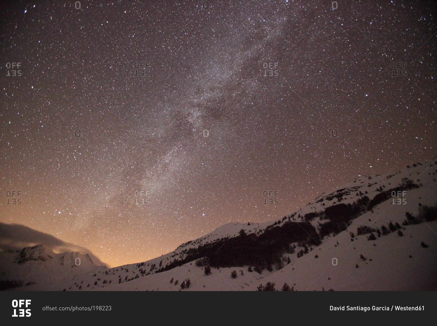 Starry sky over snow covered mountains