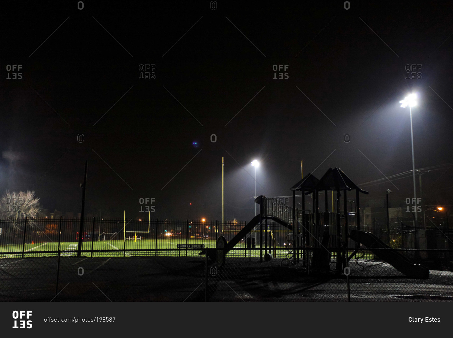 Empty school football field and playground at night