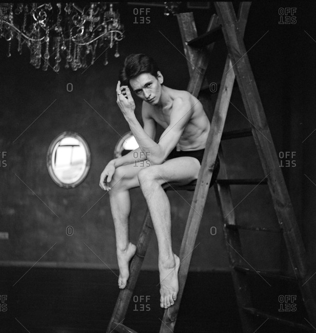 Portrait of a male dancer seated on a ladder