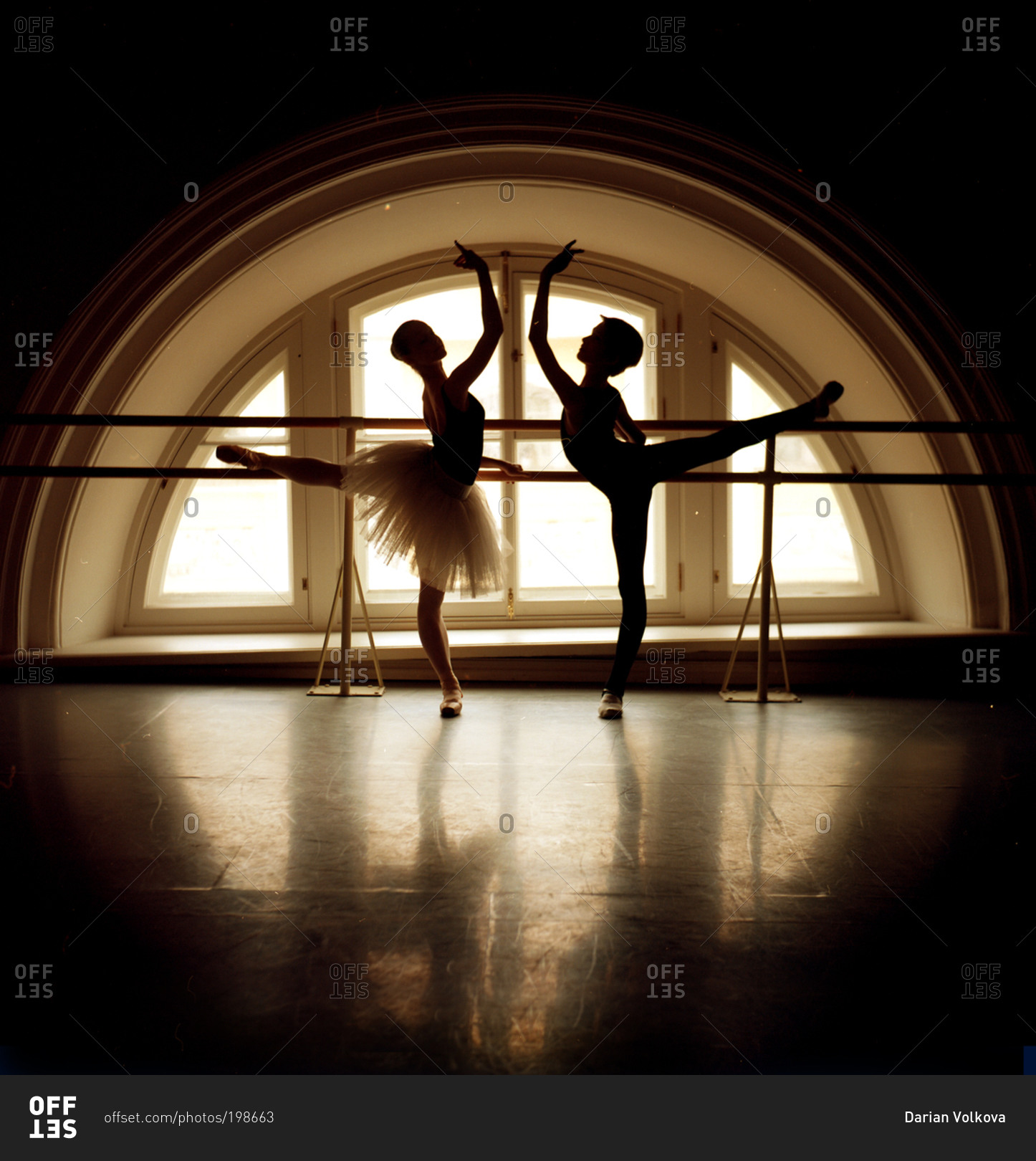 Pair of dancers in arabesque in front of window