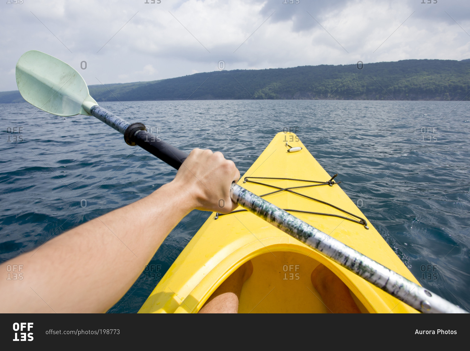 A man paddles a kayak into the middle of Skaneateles Lake, NY