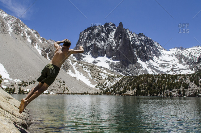 Young man jumps in a desolation lake in the John Muir Wilderness, Eastern Sierras, California