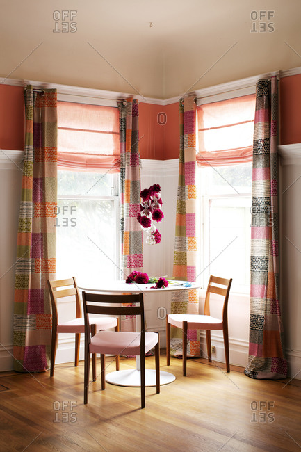 Dining Table Between Two Windows In A Pink And Orange Room