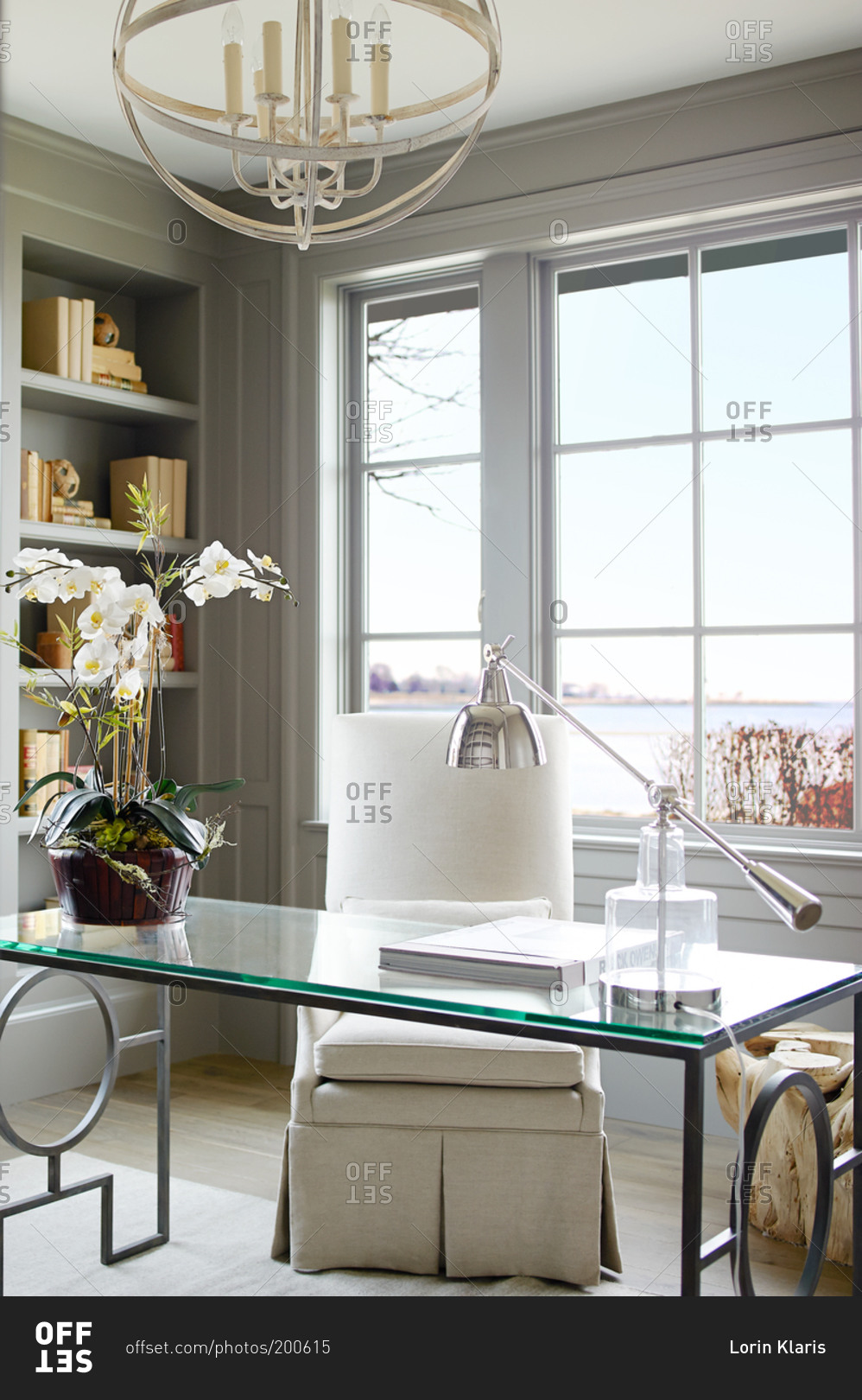 Elegant glass desk in front of a window stock photo OFFSET