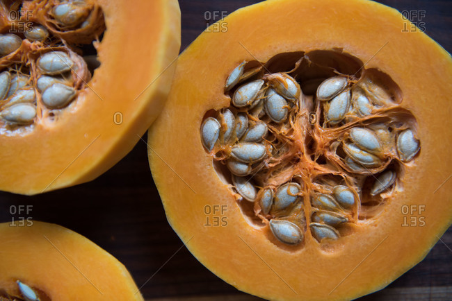 Sliced butternut squash and peels on a wooden board