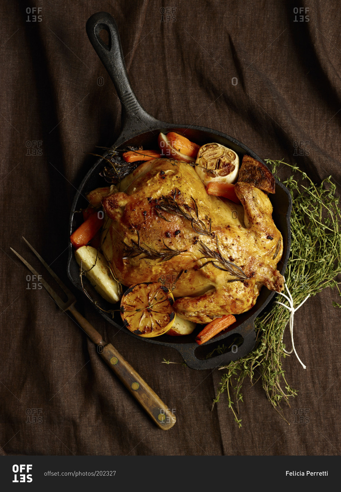 A whole roasted chicken and a carving fork