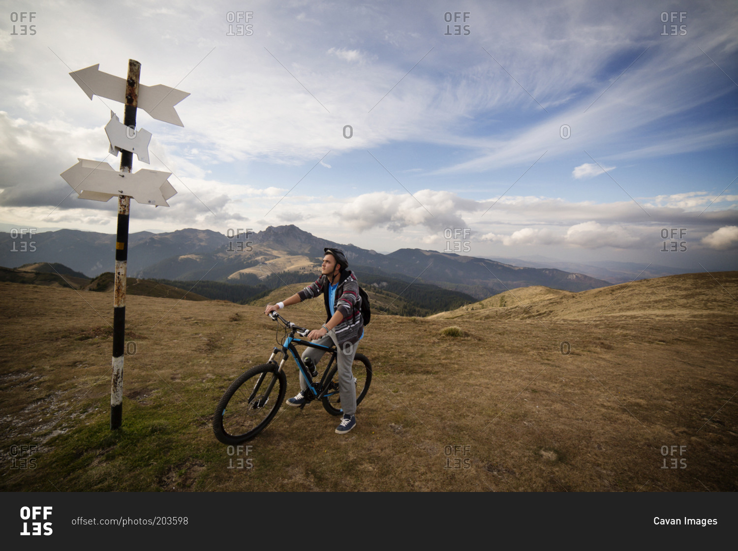 Man at signpost on mountain bike trail
