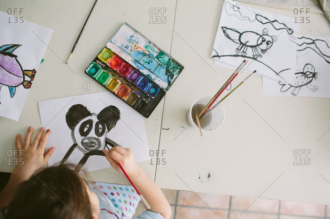 Overhead shot of child painting with watercolors