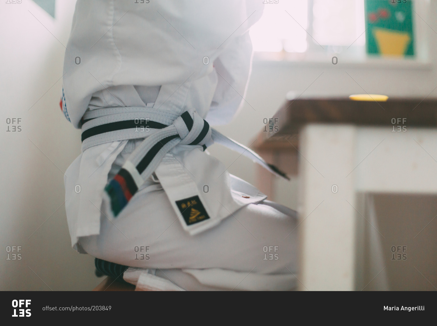 Child wearing karate uniform at kitchen table