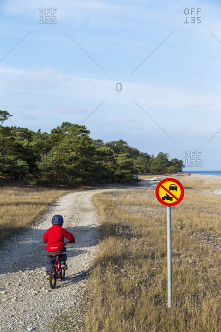 Boy on bicycle on dirt path