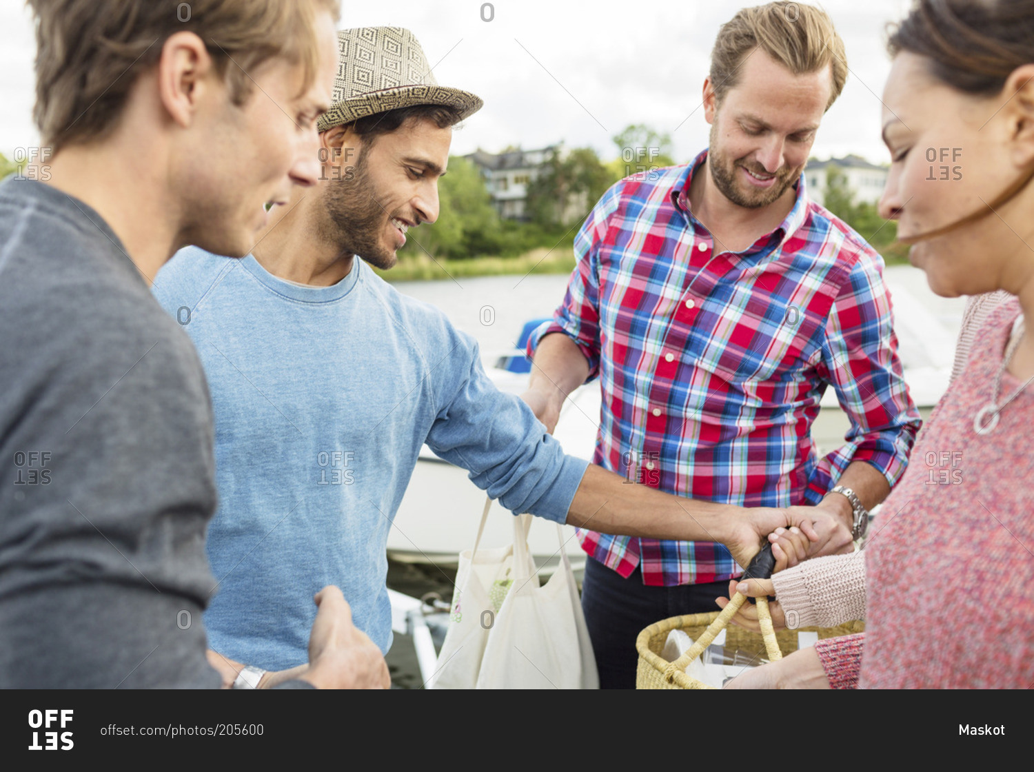 Happy friends with picnic basket outdoors