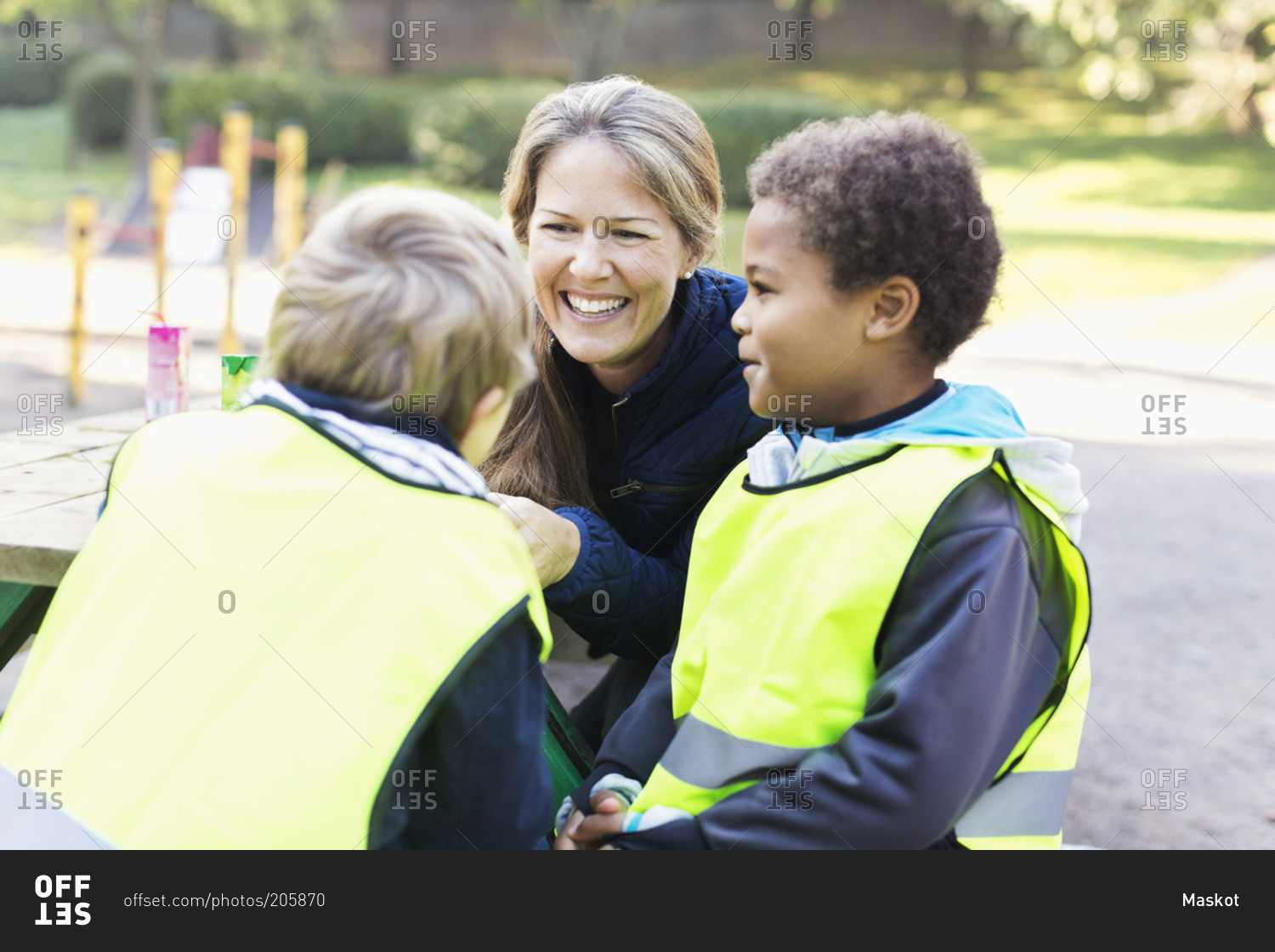 Happy teacher with children in reflective jackets