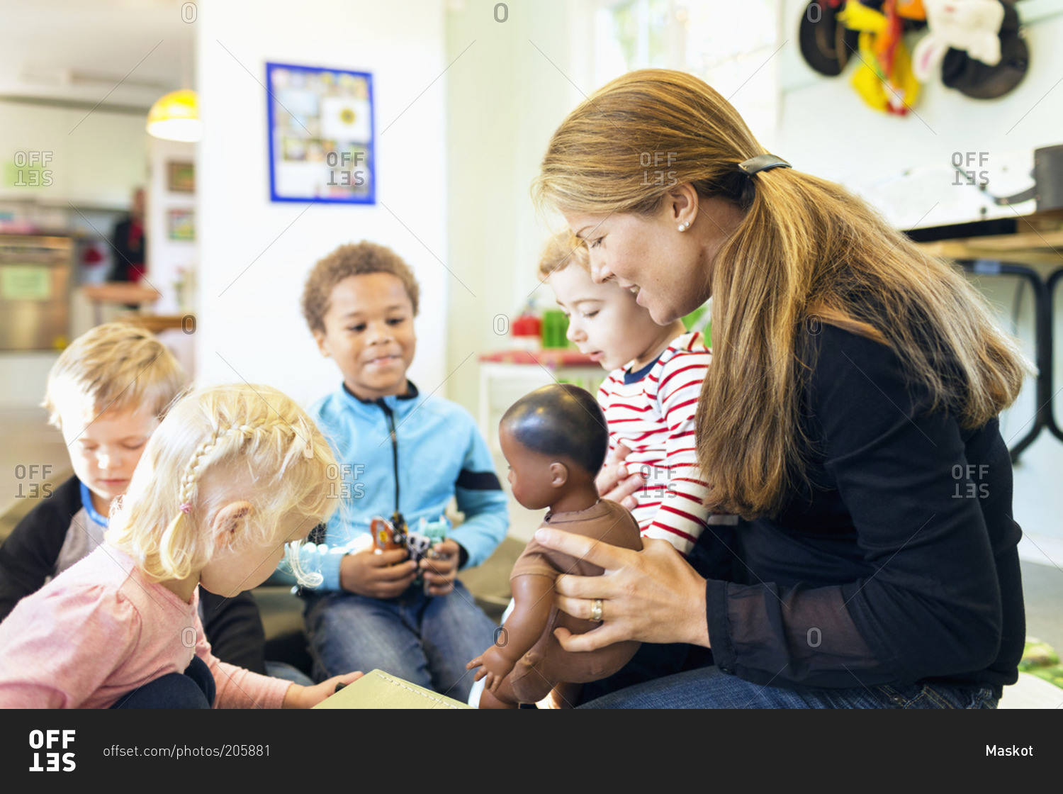 Teacher and children with toys in kindergarten